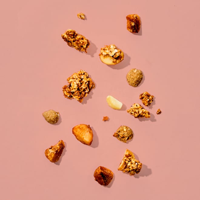 Bio Macadamia Granola Salted Caramel auf rosa Hintergrund