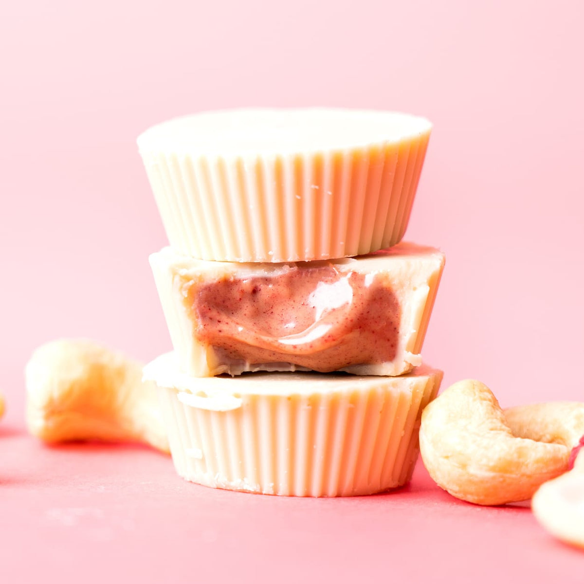 Bio Cashew Butter Cups Raspberry Rumble gestapelt mit rosa Füllung und Cashewkernen