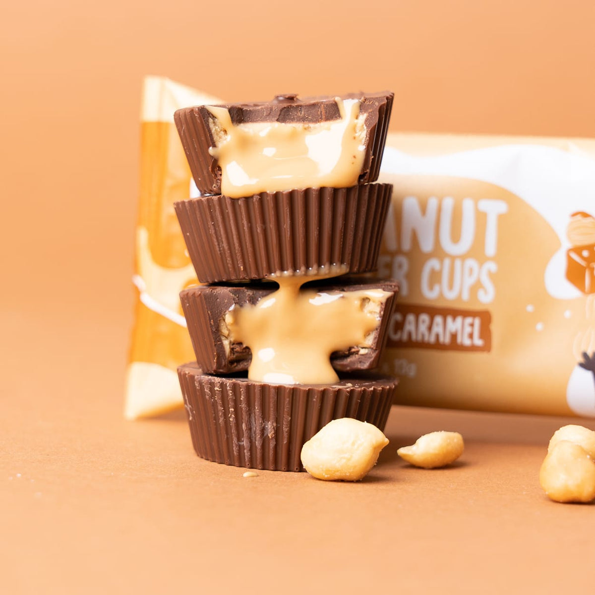 Drei gestapelte Bio Peanut Butter Cups Salted Caramel mit flüssigem Karamell und Erdnüssen